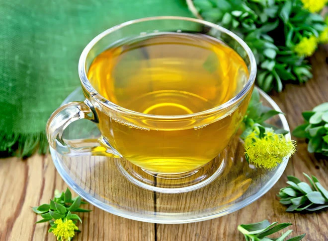Taza de té natural con hojas verdes resaltando los beneficios del té para la salud