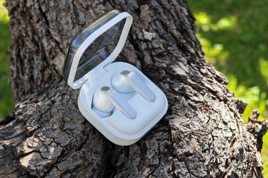 Nuevos auriculares Samsung Galaxy Buds 4 Pro en su estuche de carga con tapa transparente y acabado metálico.