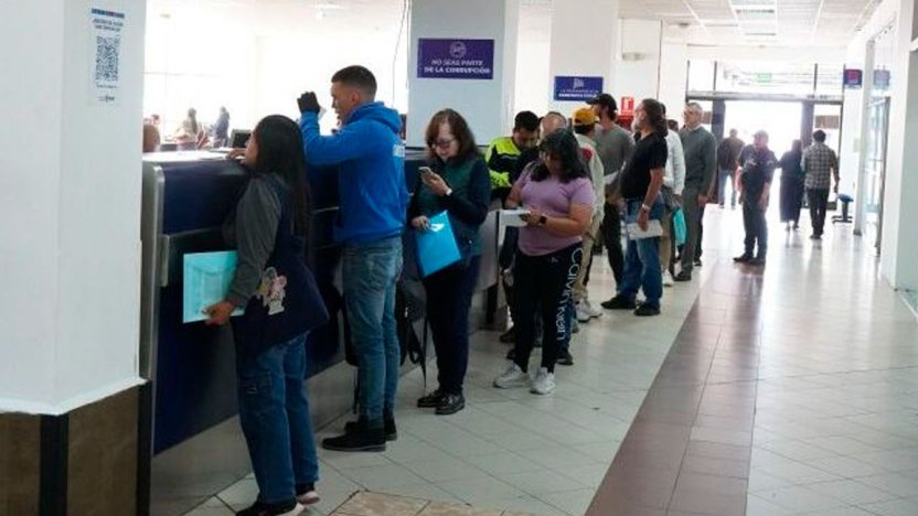 Usuarios en el Centro de Matriculación Bicentenario esperando por la matriculación de vehículos nuevos en Quito.
