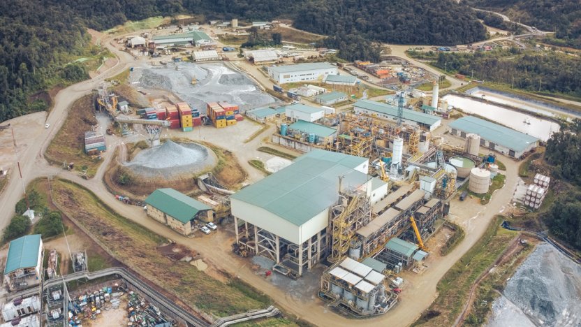Maquinaria pesada operando en una planta de beneficio minero en Ecuador bajo la supervisión de técnicos estatales.