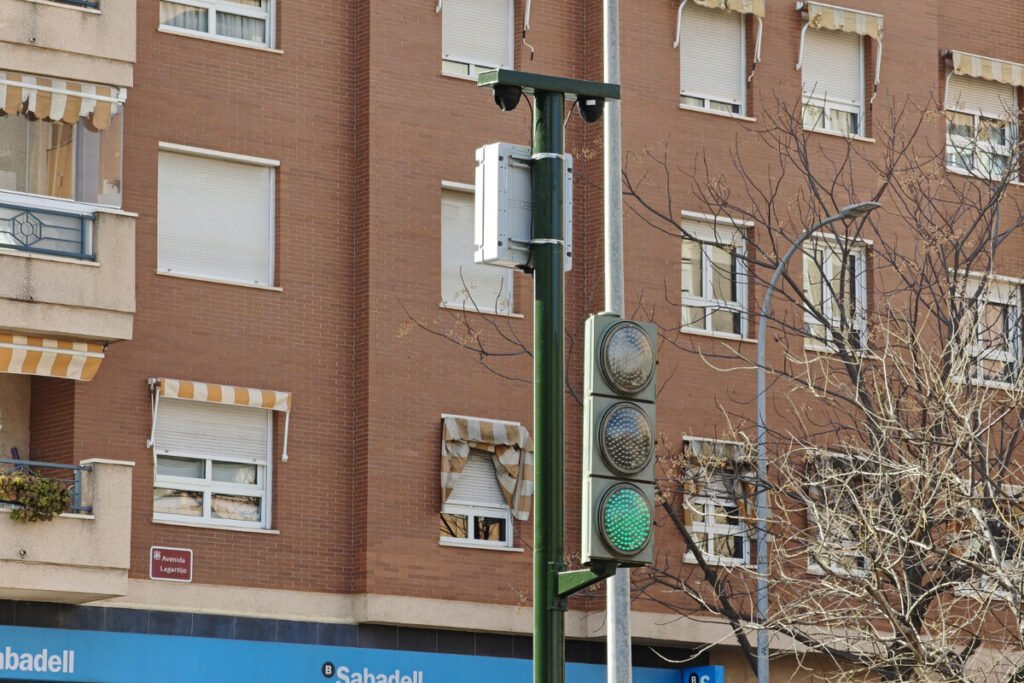 Intersección urbana equipada con semáforos conectados que operan bajo los sistemas inteligentes de transporte en España.