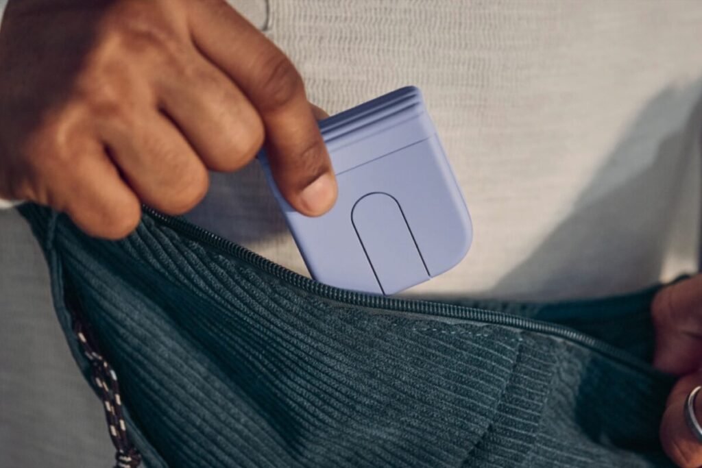 Dispositivo periférico compacto desplegado sobre un escritorio junto a un ordenador portátil, mostrando el ratón plegable Logitech Mobi Fold.