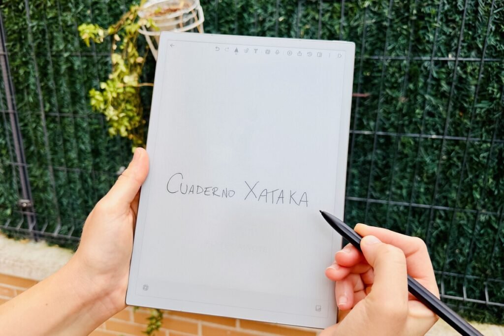 Persona tomando apuntes a mano con un stylus sobre la pantalla de tinta electrónica de un cuaderno digital de altos vuelos.