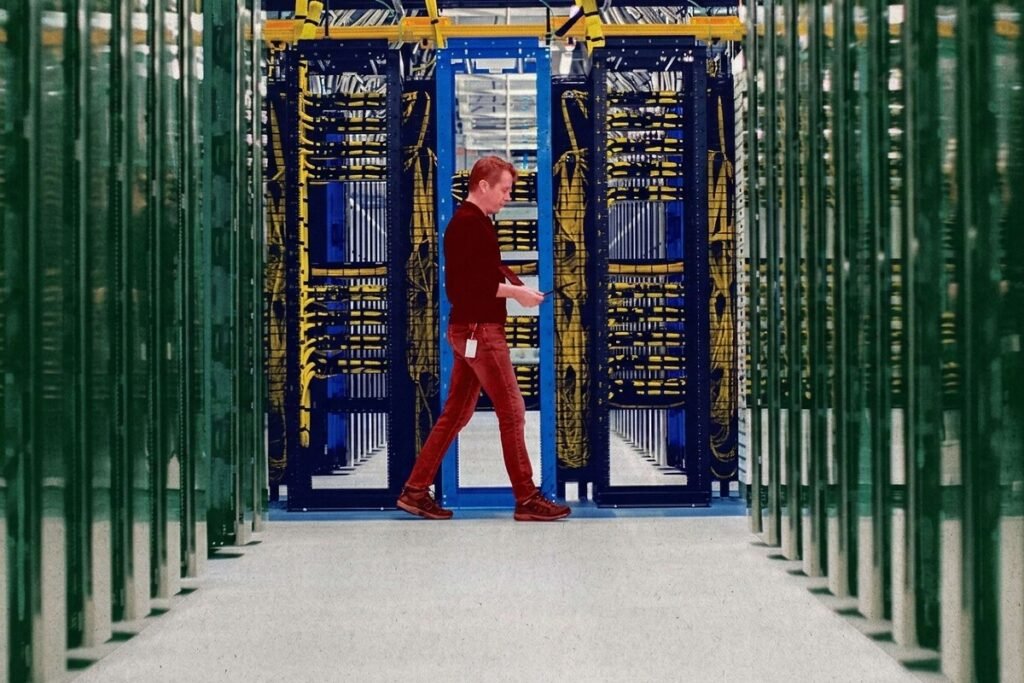 Vista aérea de un gran complejo de centros de datos con paneles solares insuficientes rodeado de torres de alta tensión, ilustrando la huella de carbono de Microsoft.