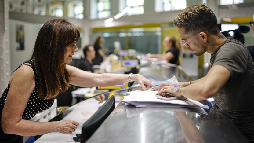 Inmigrantes realizando trámites documentales vinculados a la regularización extraordinaria de inmigrantes en una oficina pública de España.