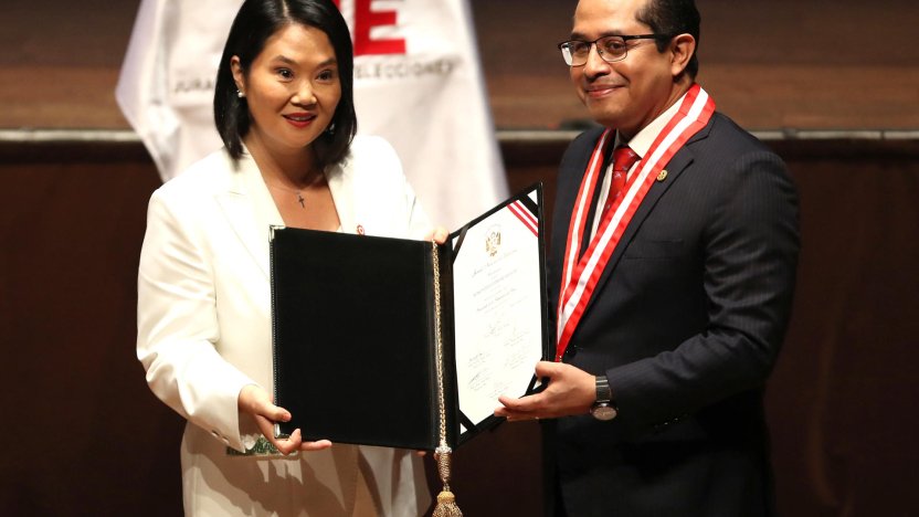Keiko Fujimori posa sonriente sosteniendo sus credenciales oficiales como presidenta electa de Perú en Lima.