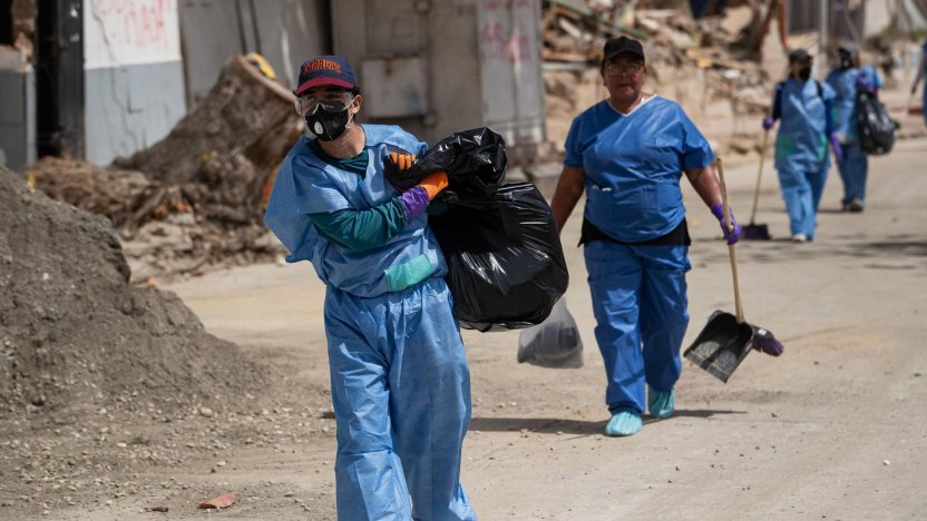 Voluntarios recogiendo desechos en un escenario donde se realiza la jornada de limpieza en La Guaira