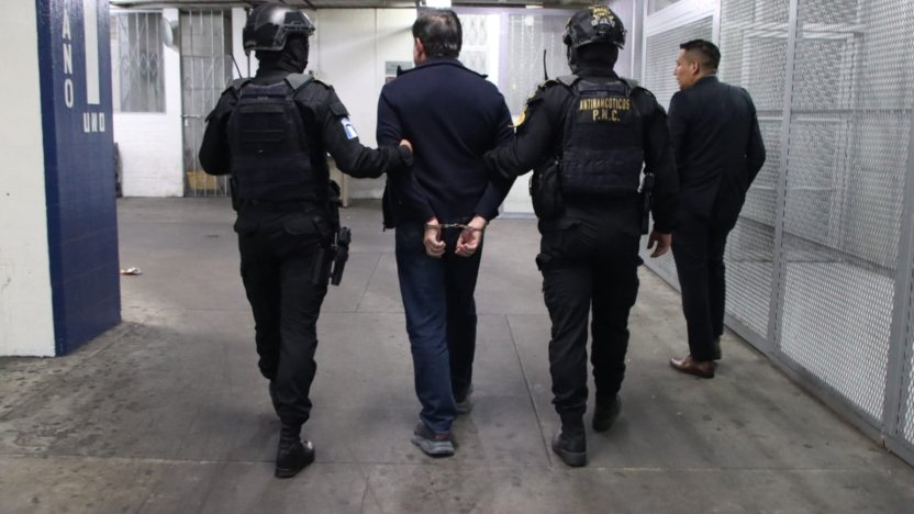 Agentes policiales custodian al detenido luego de que Guatemala captura a un ciudadano ecuatoriano
