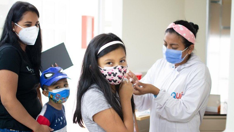 Enfermera administra dosis durante la vacunación masiva Día del Niño en un punto comunitario de Ecuador.