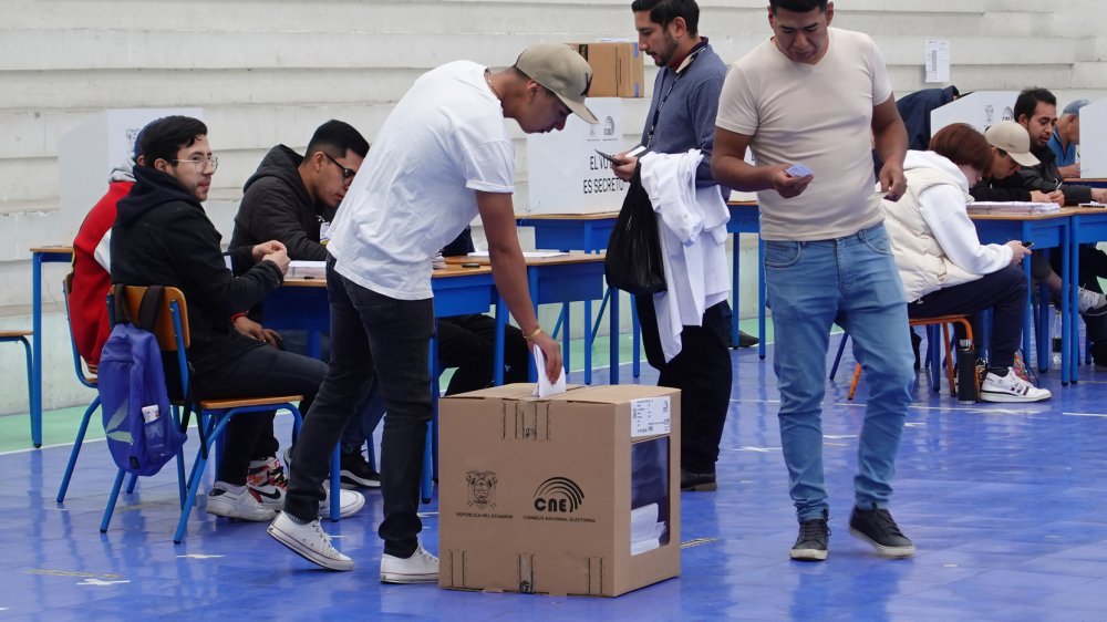 Ciudadanos ecuatorianos votando en consulta popular 2025 y referendo con urnas electorales del CNE Ecuador