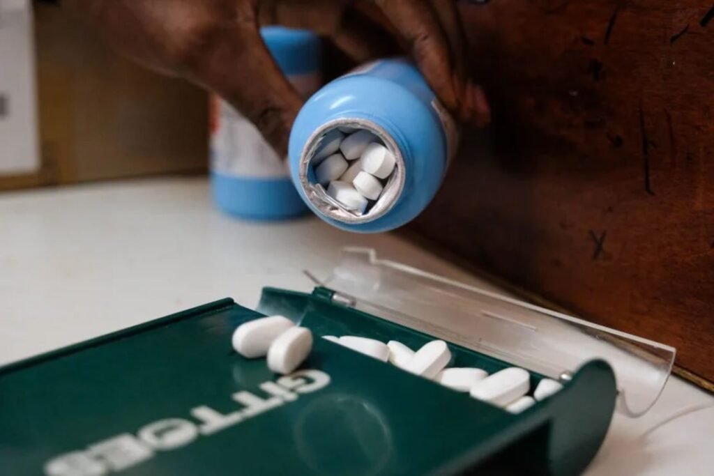 Enfermera en Kenia sostiene caja de medicamentos antirretrovirales afectados por recortes de fondos de Estados Unidos.