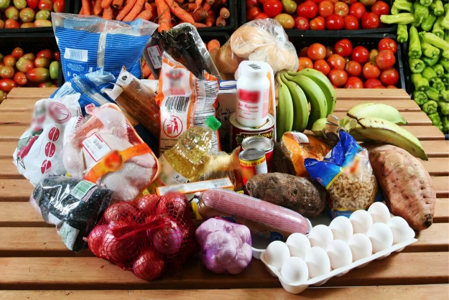 Personas comprando productos de la canasta básica familiar en un mercado de Ecuador.