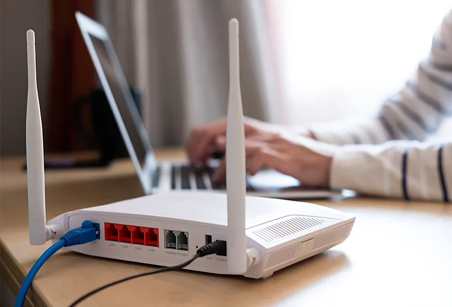 Persona usando un smartphone y un portátil conectados a una red de datos móviles como alternativa a un router de casa averiado.