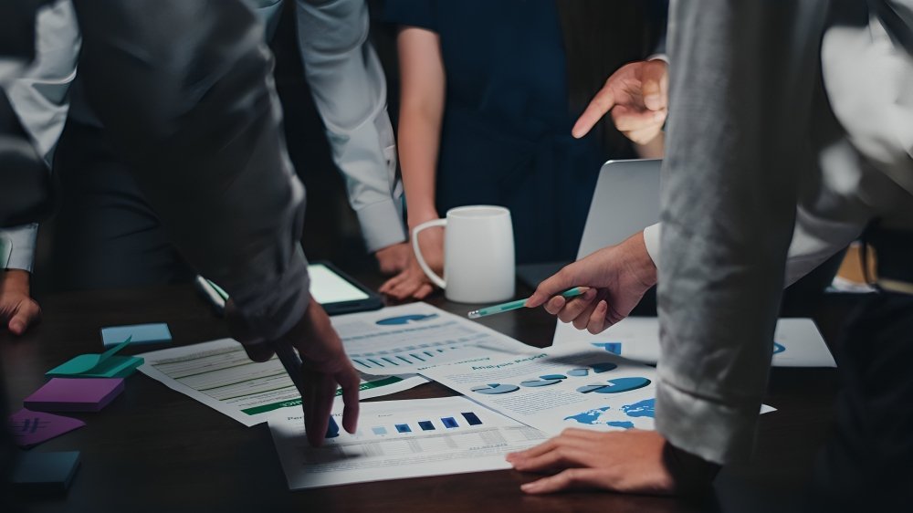 Equipo empresarial aplicando metodologías ágiles para mejorar resultados financieros en sala de trabajo colaborativa