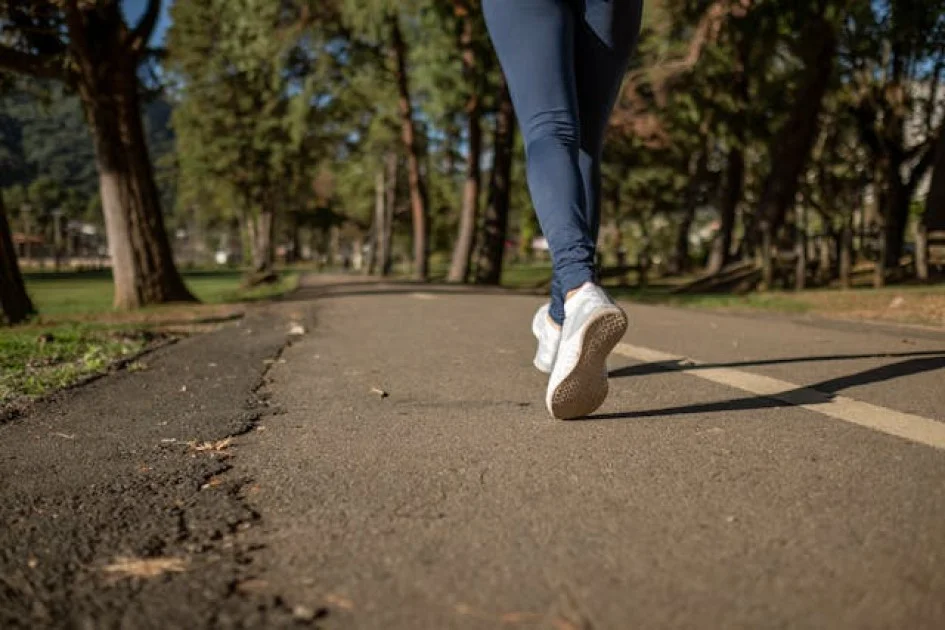 Persona trotando en un parque, promoviendo la salud mental a través del ejercicio aeróbico