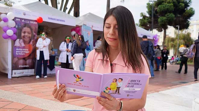 Familia revisando la nueva Libreta Integral de Salud actualizada, destacando el cuidado materno-infantil.