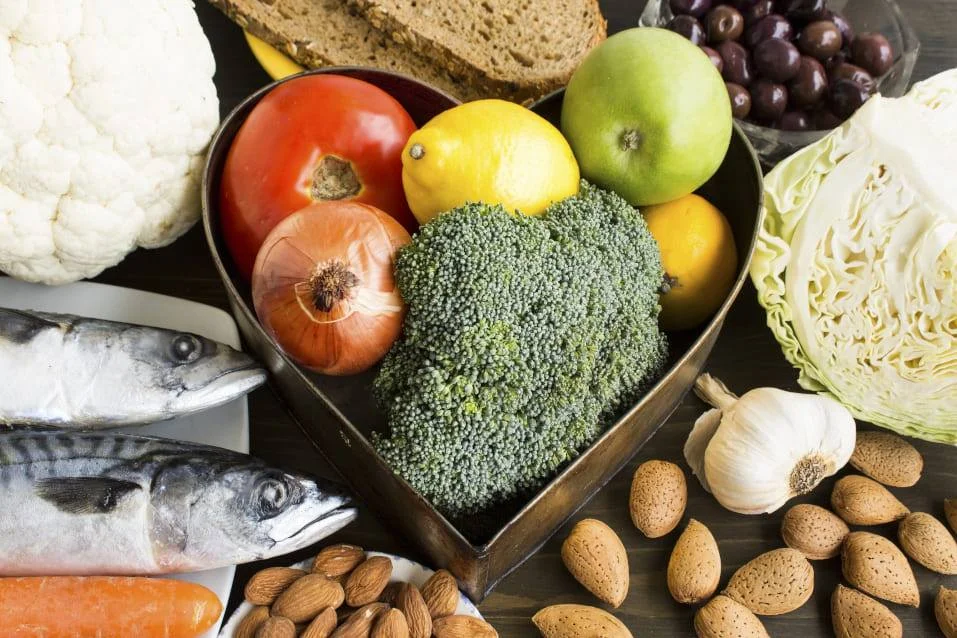 Infografía de las 9 claves de la AHA para una salud cardiovascular óptima, mostrando alimentos saludables y un corazón feliz