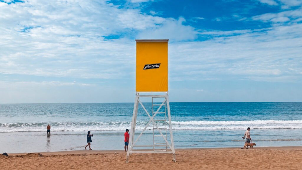 Estructura de torre salvavidas de Safety Ads DUOPRINT en playa de Manta, integrando publicidad y servicios de seguridad