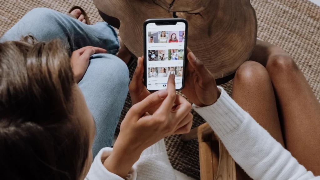 Adolescente usando el celular mientras un libro queda abierto y sin leer