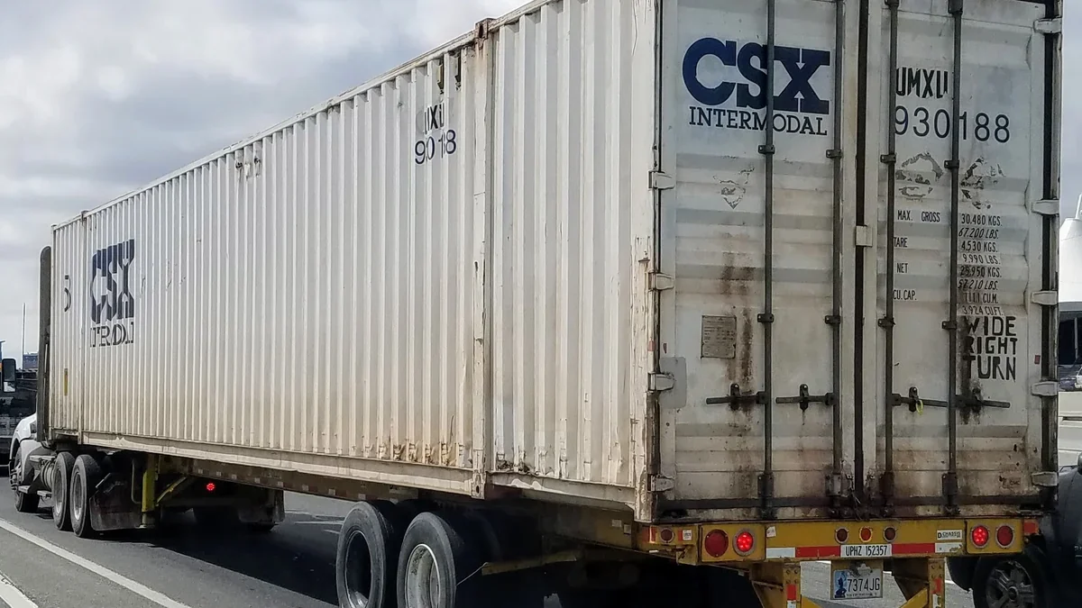 Camión de carga transportando un contenedor en una carretera