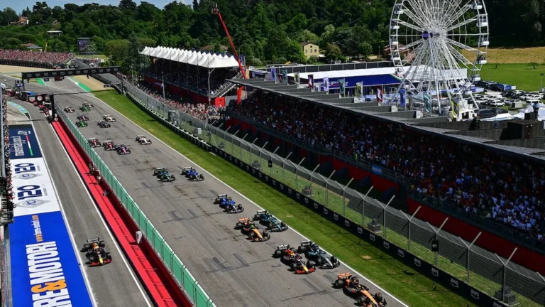 Monoplazas de Fórmula 1 compitiendo en recta principal de circuito nocturno