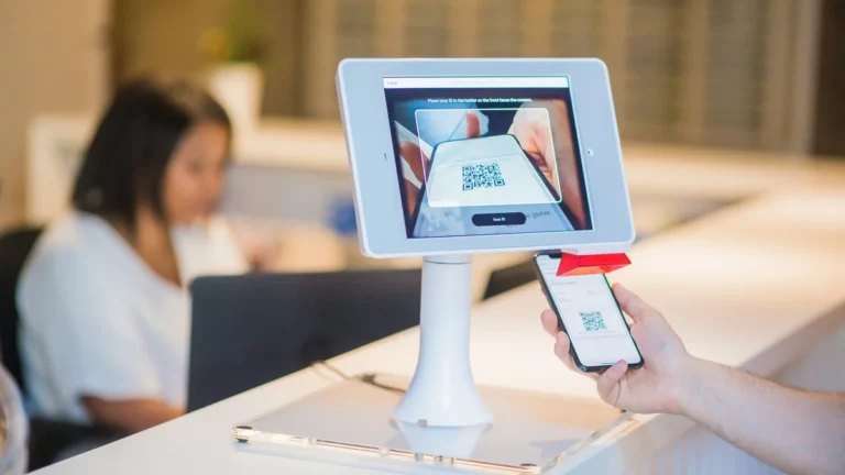 Recepción de hotel con tecnología de check-in y personal de atención