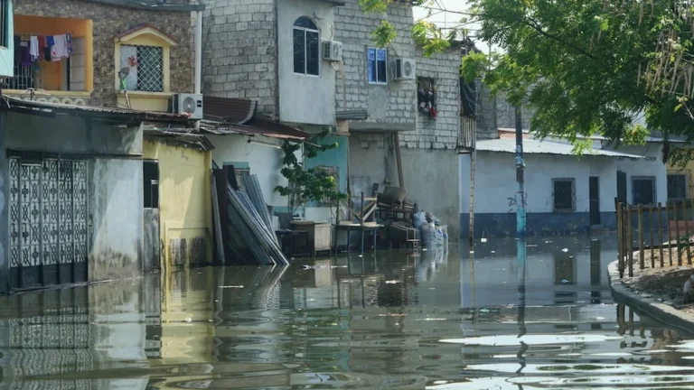Vecinos del suburbio de Guayaquil observan el nivel del agua tras la marea alta