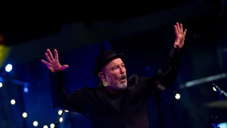 Rubén Blades cantando con sombrero y micrófono en mano durante un concierto