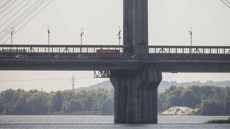 Puente urbano sobre río con columnas de humo tras impacto de ataque aéreo en Kiev