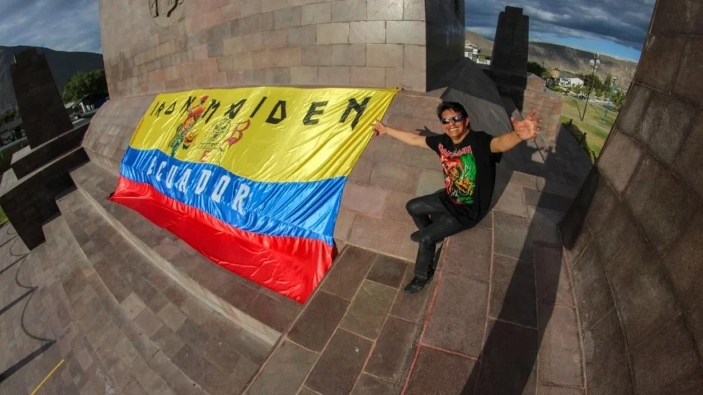 El artista Blas Guerra junto a la bandera gigante de Iron Maiden en Quito