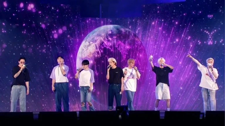 Multitud de seguidores de BTS iluminando con luces moradas en un concierto