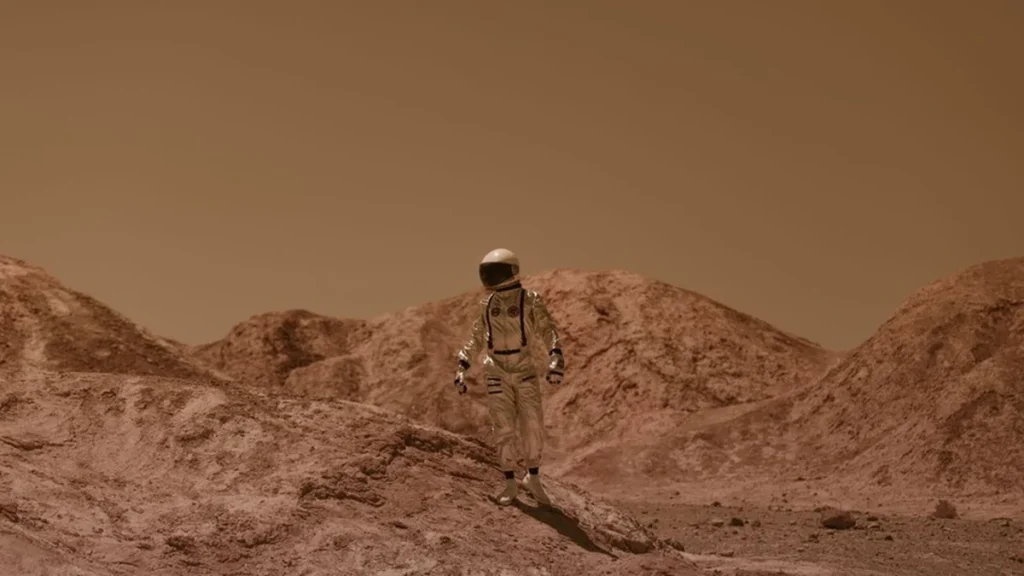 Astronauta caminando sobre la superficie desértica marciana con traje espacial
