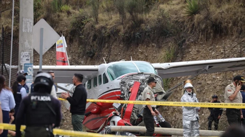 Personal técnico y grúas retirando restos de la avioneta siniestrada en Cuenca