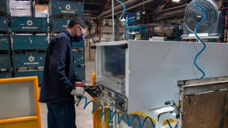 Planta manufacturera industrial con operarios en línea de ensamblaje en Cuenca