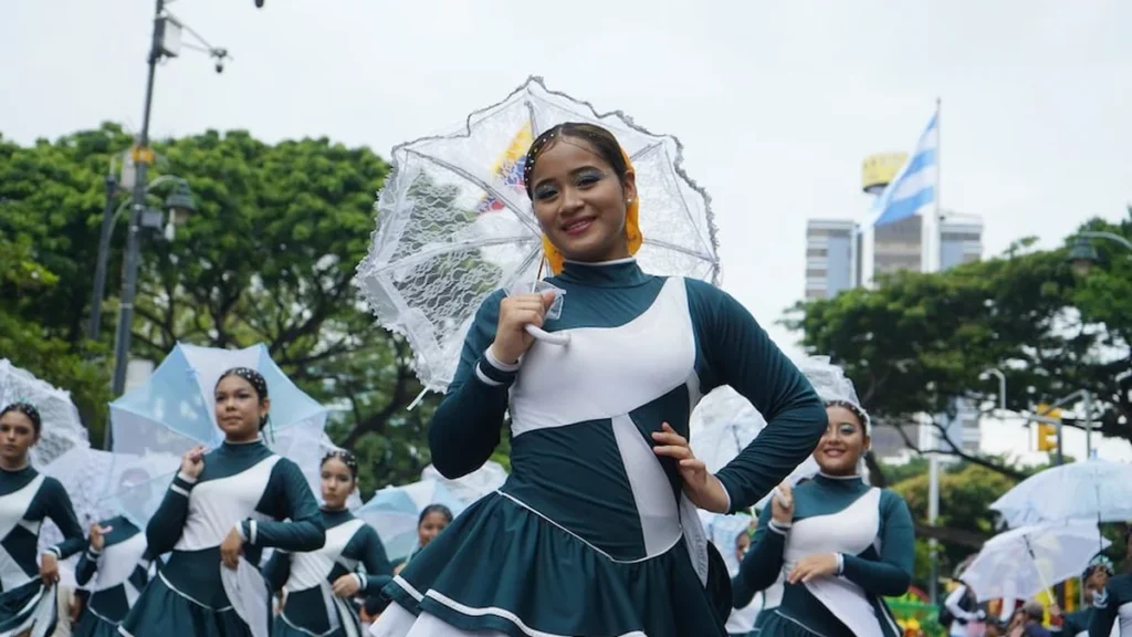 Banda musical estudiantil y banderas de Guayaquil desfilando por el Malecón 2000 en feriado