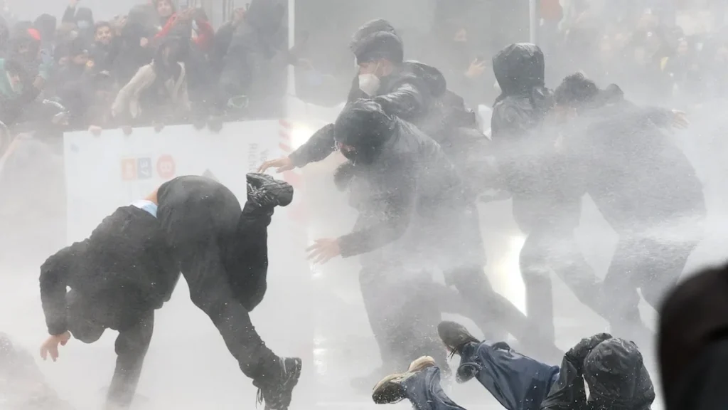 Manifestantes y policías en medio de gases lacrimógenos en las calles de Bruselas