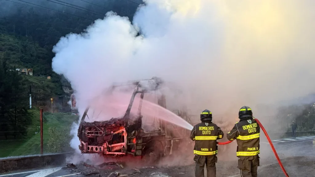 Efectivos del Cuerpo de Bomberos sofocando las llamas en un bus de transporte en Quito