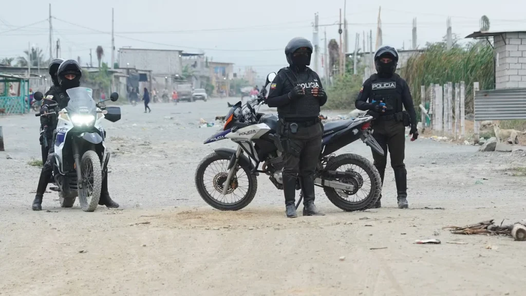 Patrulla policial y agentes acordonando una escena de crimen en Machala