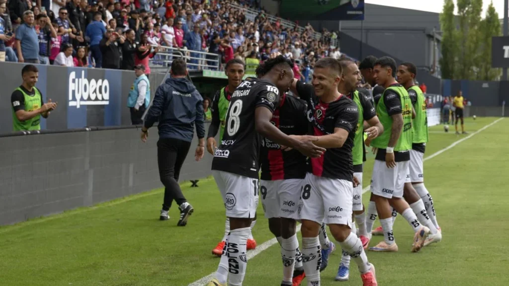 Estadio de fútbol ecuatoriano con iluminación y público en las gradas