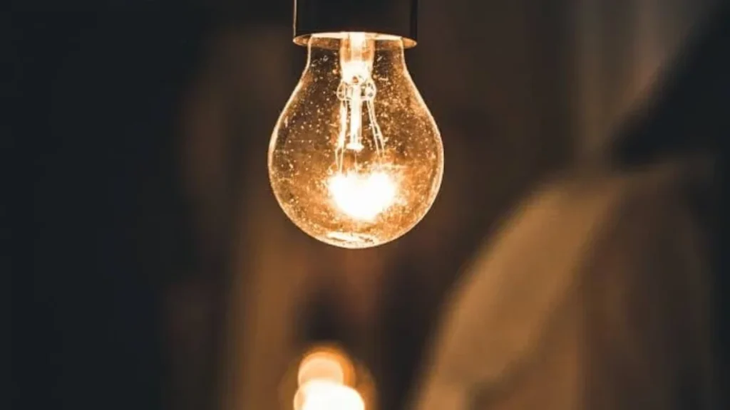 Técnicos de la empresa eléctrica trabajando en un transformador en una calle de Loja
