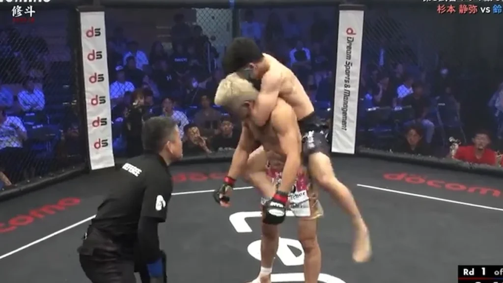 Luchadores de artes marciales mixtas combaten cuerpo a cuerpo sobre el tatami en Tokio