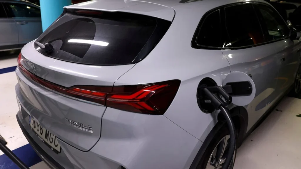 Puerto marítimo con filas de automóviles híbridos en proceso de embarque internacional